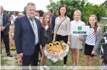 Trzy dziewczynki i dwoje doroslych z chlebem dozynkowym