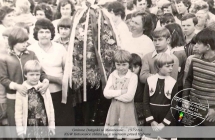 Dzieci i dorosli przy okazalym wiencu dozynkowym