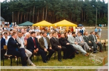 Grupa ludzi siedzacych na krzeslach na powietrzu