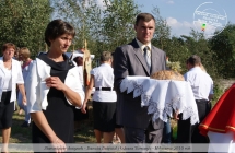 Mezczyzna i kobieta niosacy chleb dozynkowy