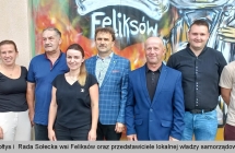 Grupa kilku osób na tle murala 